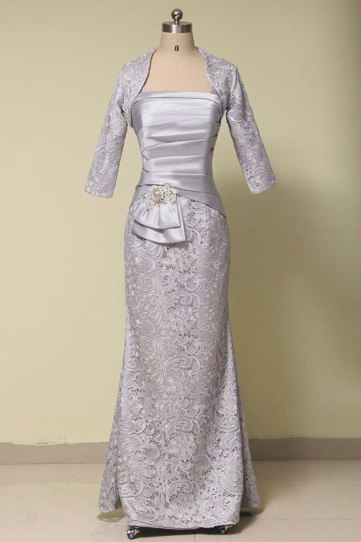 a dress on a mannequin with a jacket over the top and a bow at the waist