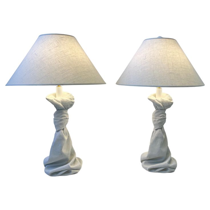 two lamps that are sitting next to each other on a white surface with one light turned on