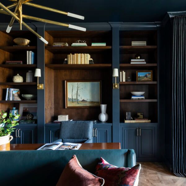 a living room filled with furniture and bookshelves next to a wall mounted book case