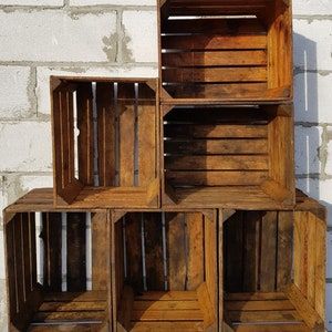 four wooden crates stacked on top of each other in front of a white brick wall