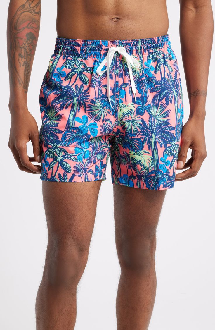 Lightweight and stretchy, these pool-to-party swim trunks feature plenty of handy pockets plus interior compression shorts for easy, supportive comfort. 5 1/2" inseam; 23 1/2" leg opening Elastic/drawstring waist Side-seam pockets; back welt pocket Interior compression shorts 91% polyester, 9% spandex Machine wash, tumble dry Imported Tropical Swim Trunks With Built-in Shorts For Poolside, Pink Swim Trunks With Built-in Shorts For Beach Season, Printed Swim Trunks For Poolside Vacation, Vacation Swim Trunks Printed For Poolside, Hawaiian Style Shorts For Pool Vacation, Hawaiian Style Swim Trunks With Built-in Shorts For Poolside, Casual Fitted Swim Trunks For Swimming, Tropical Swim Trunks With Built-in Shorts For Vacation, Fitted Tropical Swim Trunks For Pool