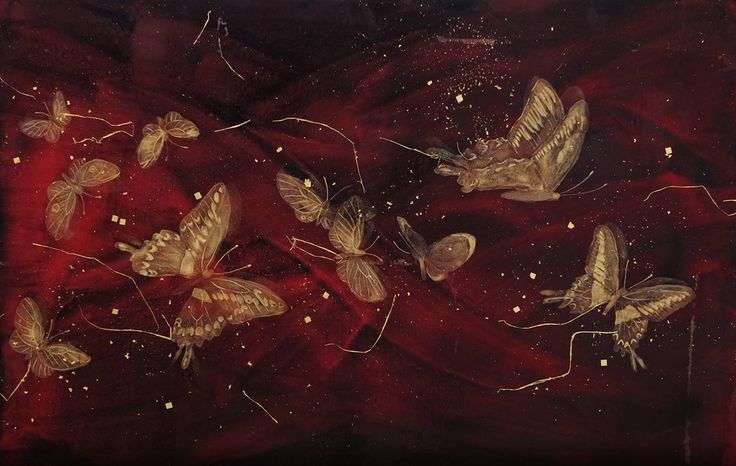 a group of moths sitting on top of a red cloth covered in gold flecks