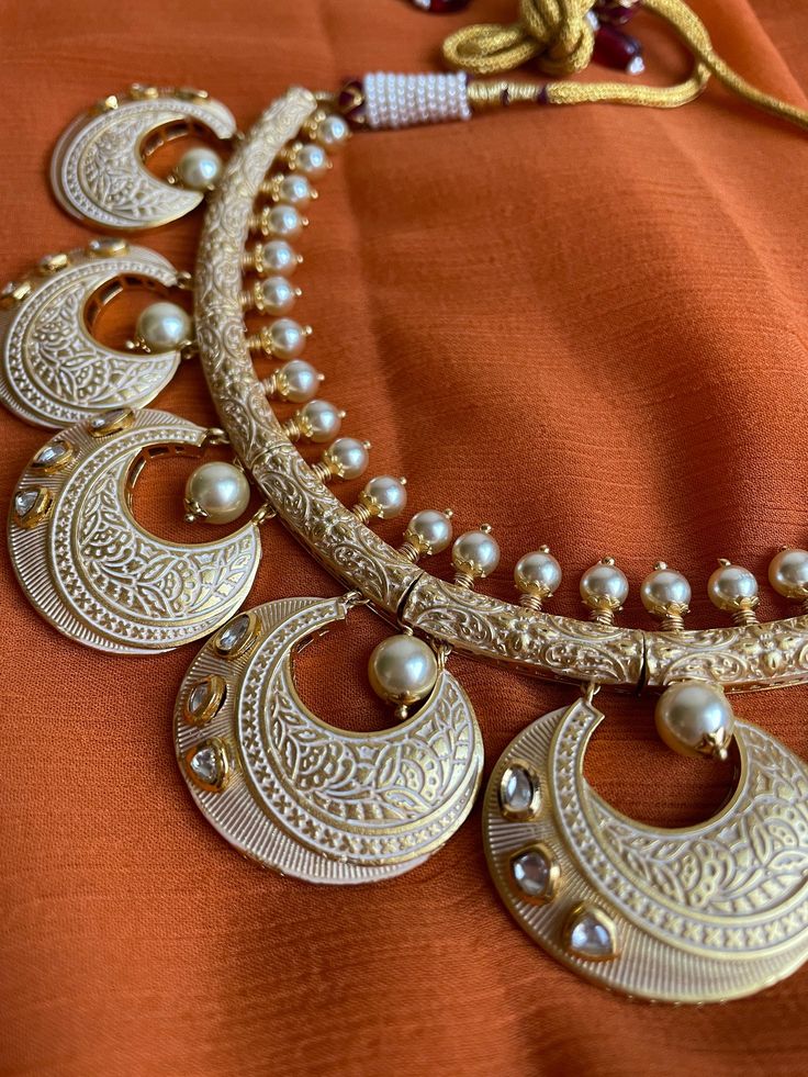 Gorgeous hasli style Rajasthani meenakari choker with kundan stones and matching earrings and tikka is the classiest piece of jewelry! This set is beautifully hand crafted and is very lightweight and versatile to wear! Traditional Kundan Necklaces For Eid, Heavy Chandbali Necklaces For Festive Season, Bollywood Chandbali Necklaces For Eid, Bollywood Style Chandbali Necklaces For Eid, Elegant Metal Kundan Necklace With Meenakari, White Kundan Necklace With Meenakari In Temple Jewelry Style, Gold Meenakari Kundan Jewelry Sets, Festive Chandbali Temple Necklace With Stone Work, Round Kundan Temple Necklace For Diwali