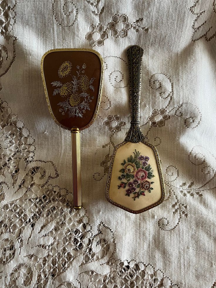 2 vintage vanity hair burshes from the late 50's/early 60's. The hair brushes are sold separately. 1950's Embroidery Floral Hair brush- Regent Made in England Lovely n colourful stitches pattern designed brush with a protective plastic insert...but is the very ornate and heavy brass tone metal frame and handle that caught my eye. Overall the brush is in very good vintage condition just a bit of wear on the light cream fabric. $29.00 1950's Brown Silver n Gold Floral Hair Brush Pretty little hair brush in a gold tone metal frame accented with a ribbon cut handle and an etching on the brush frame. Overall the brush is in wonderful vintage condition. $25.00 Vintage Hairbrush Aesthetic, Vintage Hair Brush Set, Old Hairbrush, Antique Hair Brush, Hair Brush Aesthetic, Vintage Beauty Products, Vintage Hairbrush, 1950's Hair, Vintage Hair Brush