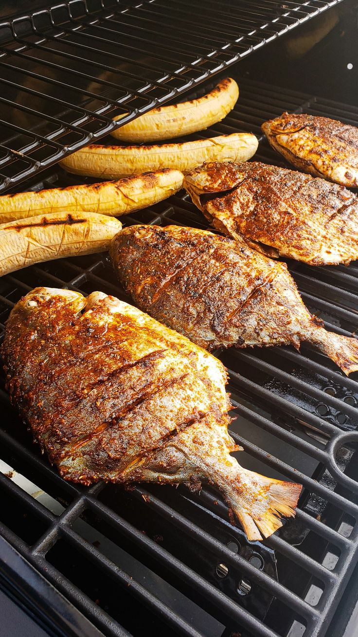 fish and french fries are cooking on the grill