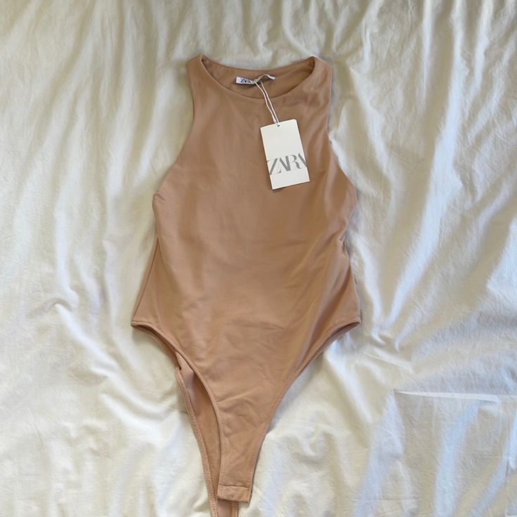 Beige/Tan Beige Sleeveless Swimwear For Spring, Sleeveless Beige Bodysuit For Summer, Sleeveless Brown Bodysuit For Summer, Fitted Beige Swimwear For Spring, Brown Sleeveless Bodysuit For Summer, Beige Sleeveless Bodysuit For The Beach, Sleeveless Beige Bodysuit For The Beach, Chic Beige Bodysuit For Spring, Beige Lined Swimwear For Spring