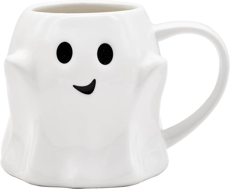 a white coffee mug with black eyes and a ghost face on it's side