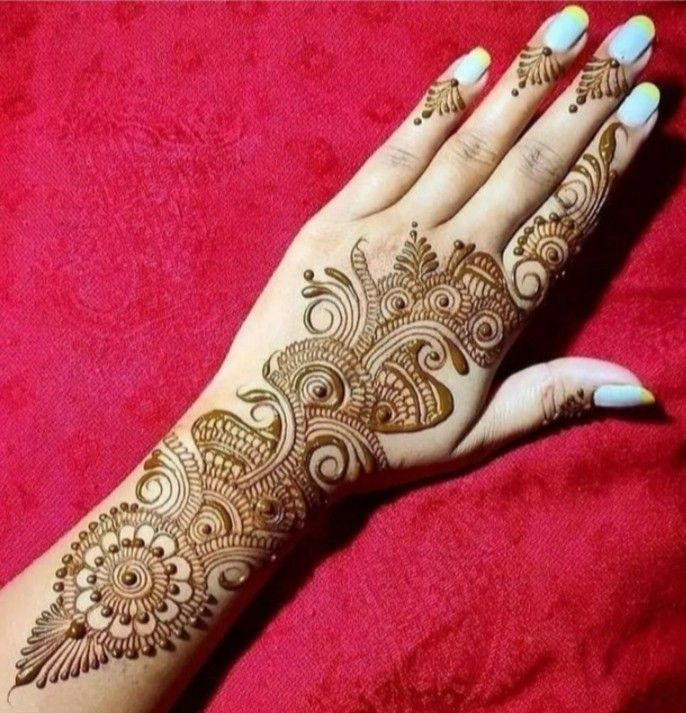 a woman's hand with henna tattoos on her left arm and the top half of