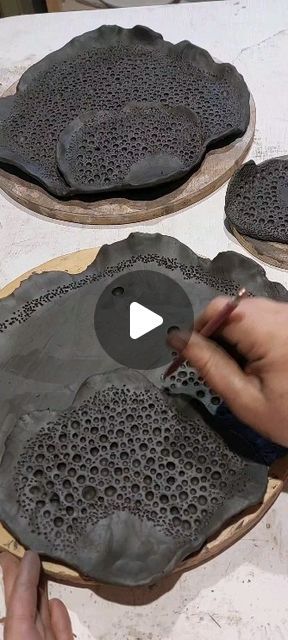 a person is making decorative plates out of clay