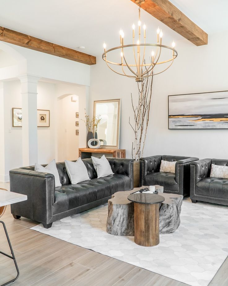 a living room filled with furniture and a chandelier hanging over the top of it