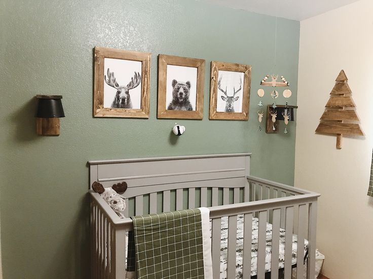 a baby's room decorated in green and white with pictures hanging on the wall