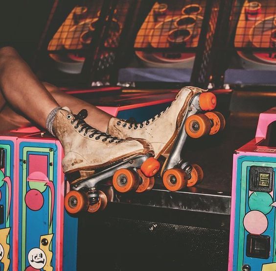 a person sitting on top of a skateboard in front of two colorful boxes with wheels