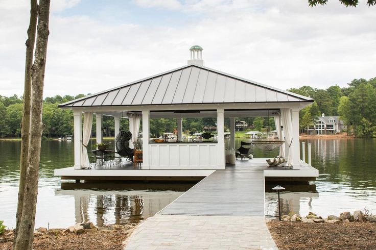 a white gazebo sitting on top of a lake next to a dock