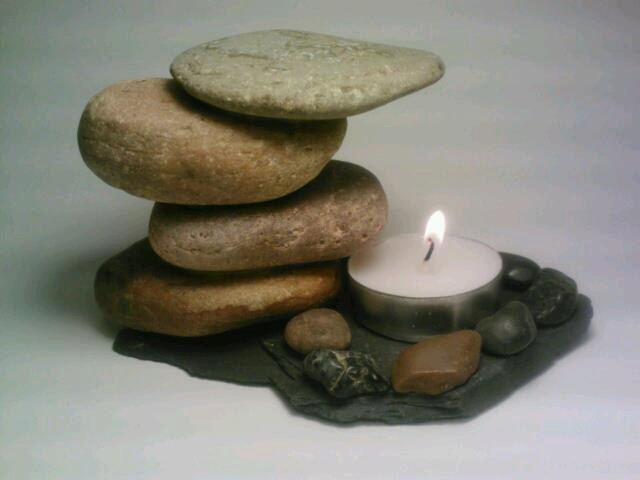 a stack of rocks with a lit candle