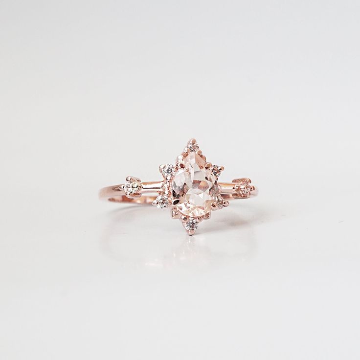 This ring is an elegant beauty for the ages. A peachy morganite set 14K solid gold. Definitely a timeless classic. Available in yellow gold vermeil, rose gold, and silver. Material: - 14K solid gold - Natural Morganite 7x5mm - Round CZs **This item is made to order, please allow 1-2 weeks for your order to be shipped. Shipping: Domestic: Ship via USPS priority mail International: $15 for international standard shipping. $10 to Canada. Online Return Policy: Due to the made to order nature, this r Heirloom Morganite Diamond Ring For Formal Occasions, Classic Morganite Diamond Ring In Yellow Gold, Fine Jewelry Morganite Diamond Ring In Rose Gold, Fine Jewelry Rose Gold Morganite Diamond Ring, Classic Morganite Diamond Ring For Formal Occasions, Elegant Morganite Rings With Diamond Accents, Rose Gold Rings With Diamond Accents And Morganite, Timeless Morganite Rose Gold Jewelry, Timeless Morganite Ring With Center Stone