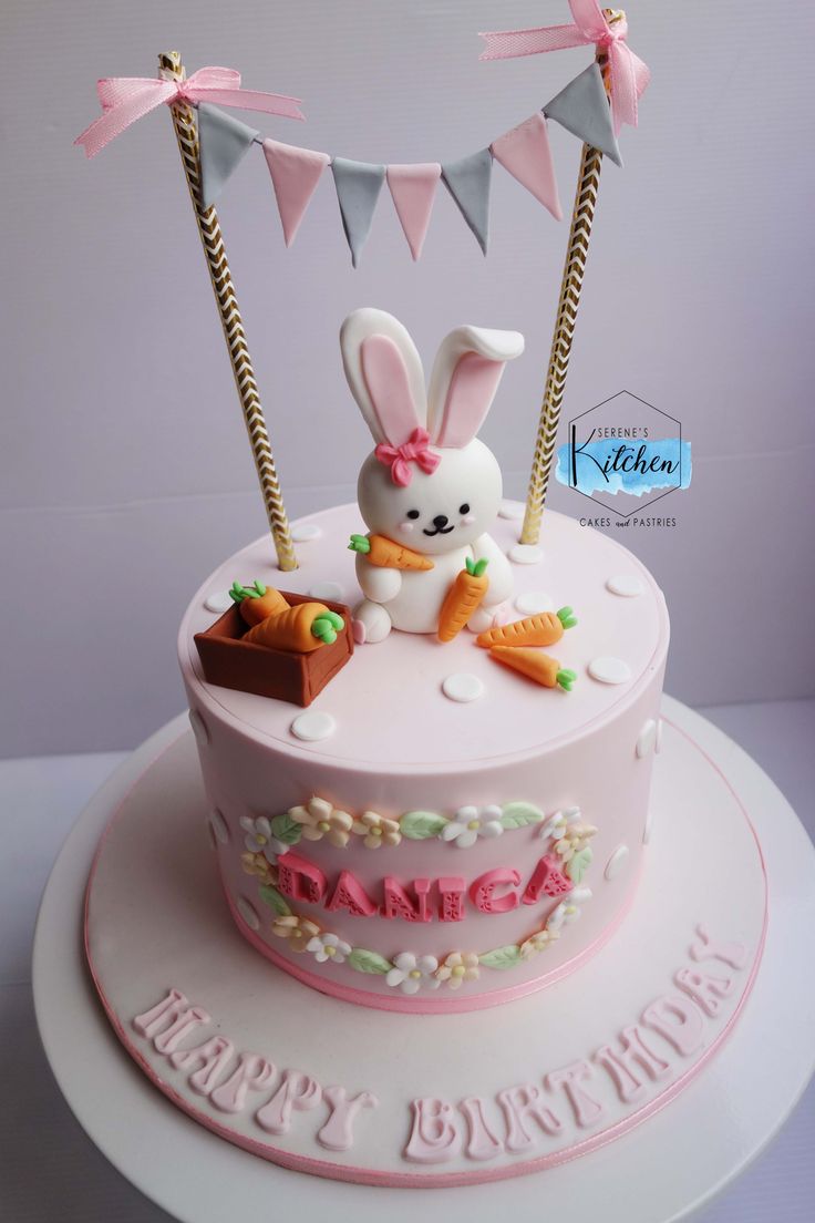 a birthday cake decorated with bunnies, carrots and an easter bunny on top