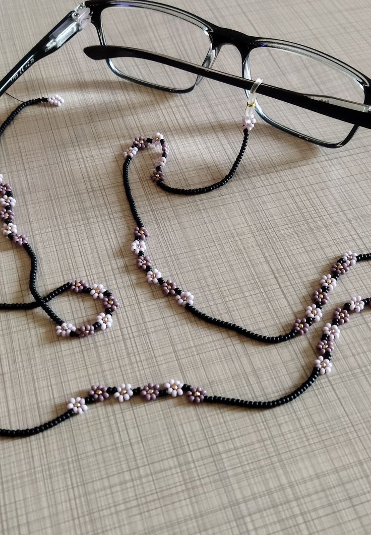 It is carefully made with black and lilac colored beads. It will be a special gift for your loved one You can send me your different color designs via message, I will make it special for you.  please browse my shop: https://www.etsy.com/shop/MiaJewelryStudio barefoot sandals: https://www.etsy.com/shop/MiaJewelryStudio?ref=profile_shopicon§ion_id=22805011 anklets : https://www.etsy.com/shop/MiaJewelryStudio?ref=profile_shopicon§ion_id=25969168 necklace: https://www.etsy.com/shop/MiaJewelryStudio? Trendy Purple Beaded Necklace For Gift, Trendy Black Glasses Chains For Gift, Black Beaded Glasses Chain With Round Beads, Black Beaded Glasses Chains, Trendy Black Beaded Glasses Chains, Elegant Black Beaded Glasses Chains, Adjustable Black Beads Glasses Chains For Gift, Adjustable Black Beads Glasses Chains As Gift, Adjustable Beaded Black Glasses Chains