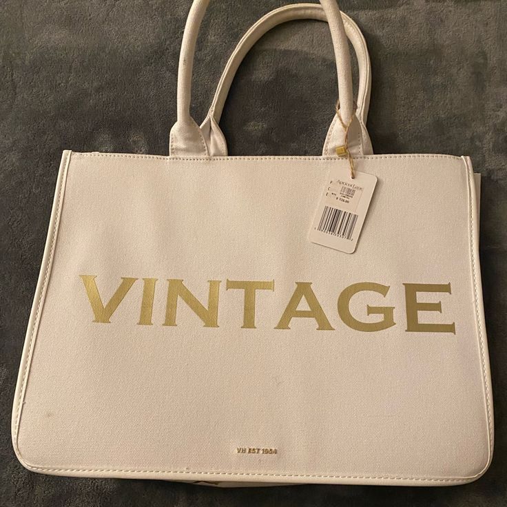 White Canvas Bag With Hard Sides In Gold Lettering It Says “Vintage” On One Side And “Vintage Havana” On The Bottom. Vintage Satchel With Large Capacity For Errands, Vintage Satchel For Errands With Large Capacity, Vintage Large Capacity Satchel For Errands, Vintage White Rectangular Bag, White Vintage Rectangular Bag, White Rectangular Vintage Bag, Vintage White Shoulder Bag With Large Capacity, Vintage White Tote Shoulder Bag, Retro Cream Bag For Daily Use