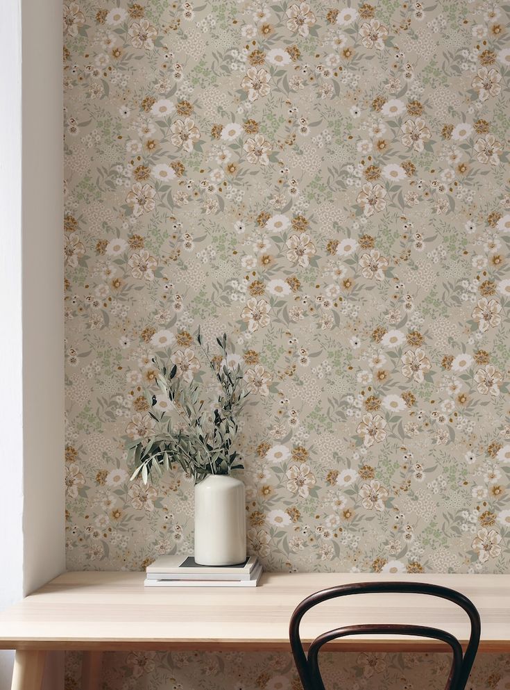 a wooden table topped with a plant next to a white vase filled with flowers on top of it