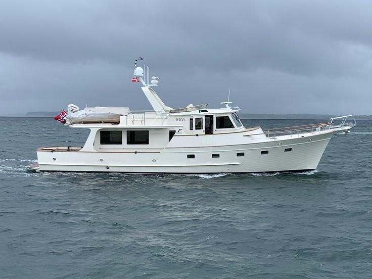 a white boat in the ocean on a cloudy day