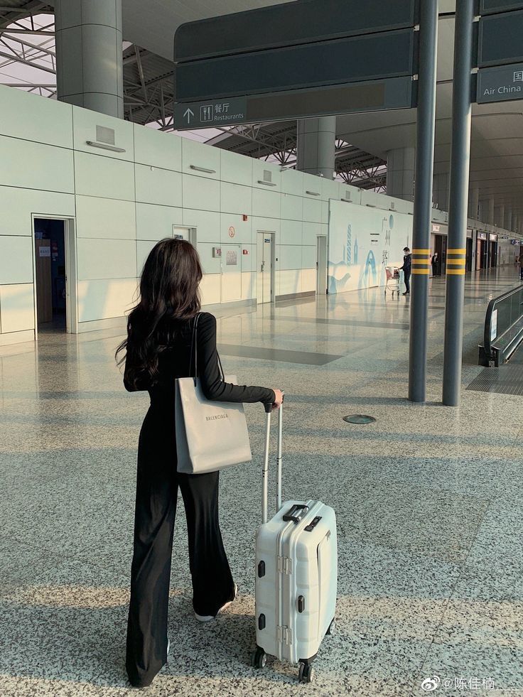 a woman with a suitcase in an airport