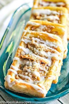 cinnamon rolls on a plate with icing drizzled over them, ready to be eaten