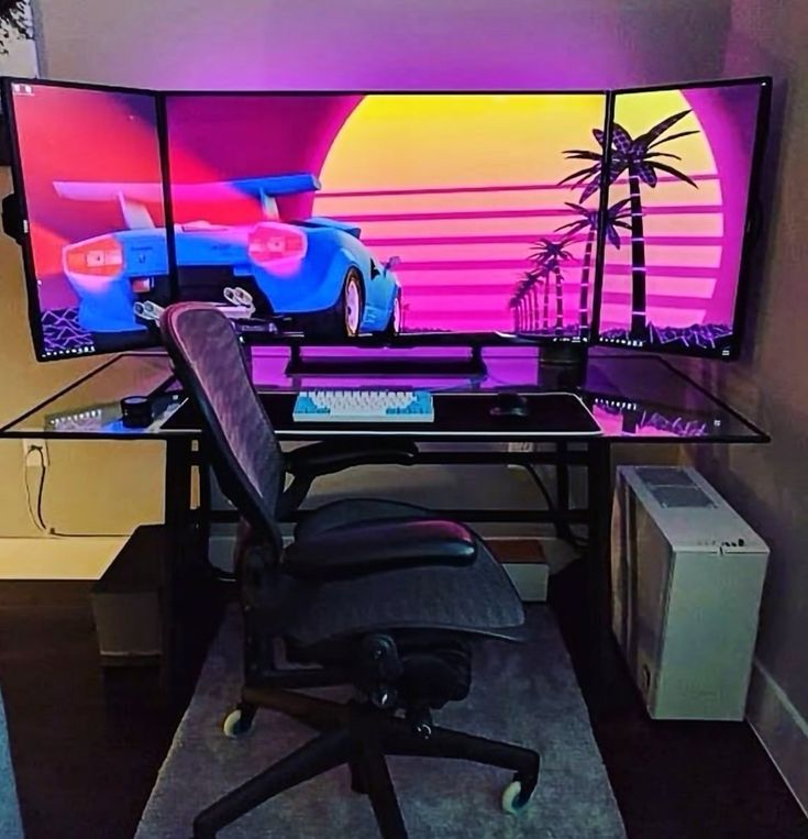 a desk with a computer monitor on it and a gaming chair in front of it