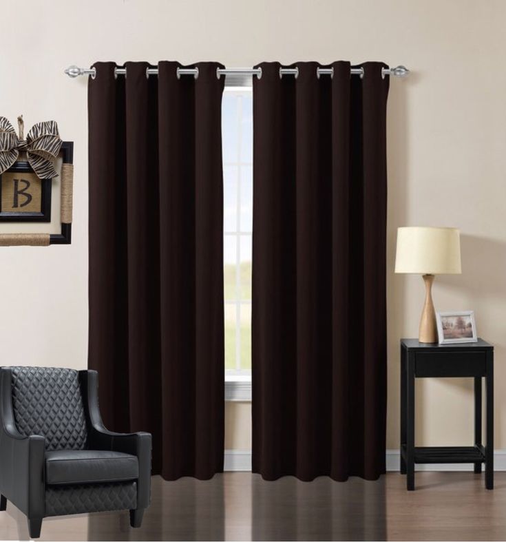 a living room filled with furniture and a window covered in dark brown drapes