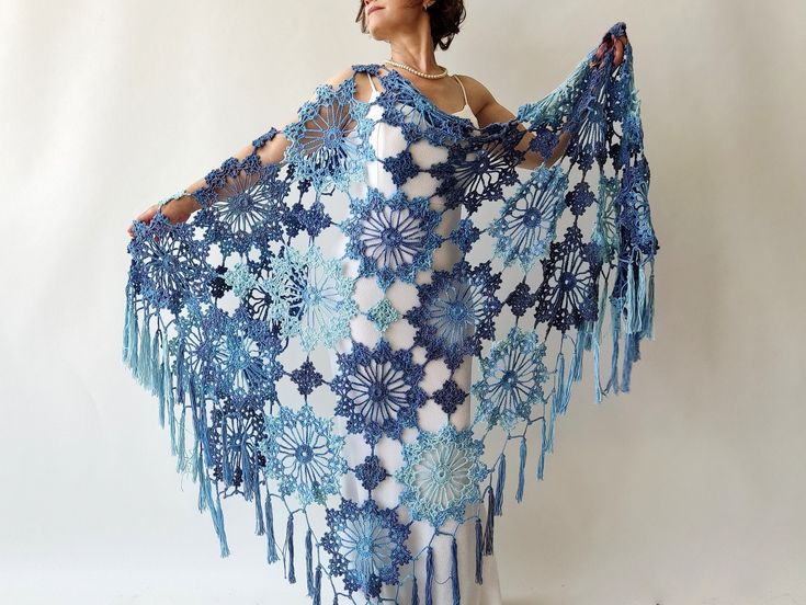 a woman wearing a blue and white crocheted shawl