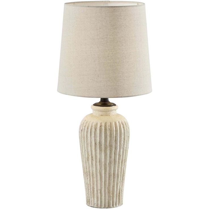 a white ceramic lamp with a beige shade on the base and a light brown linen shade on the top