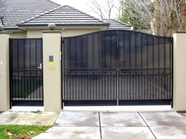 an iron gate is open on the side of a house