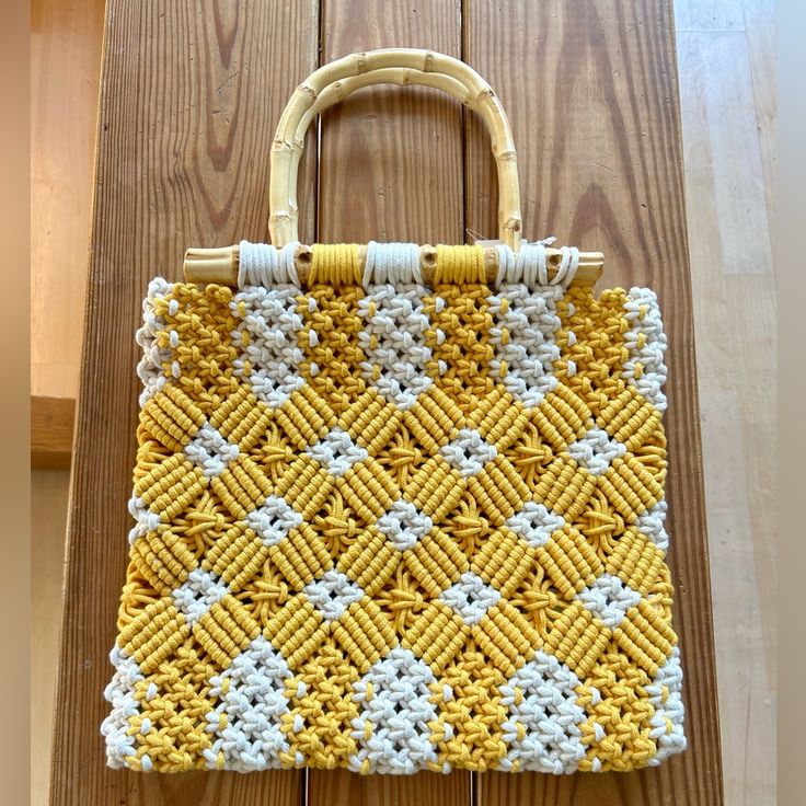 a yellow and white purse sitting on top of a wooden table