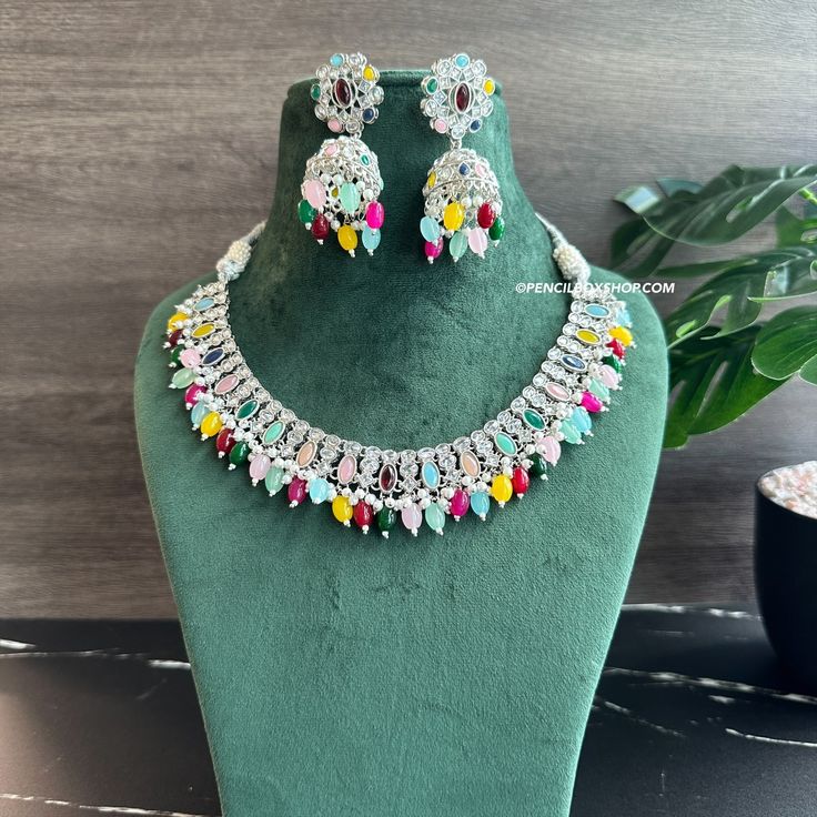 Anvi Multicolor Silver Polki Necklace Set with Maangtikka. Expertly crafted with precision and intricate detailing, the Anvi Multicolor Silver Polki Necklace Set with Maangtikka is a must-have statement piece for any occasion. The stunning multicolor stones and shimmering silver polki add a touch of elegance and sophistication to any outfit. Elevate your style and make a bold statement with this exquisite jewelry set. Multicolor Gemstone Temple Jewelry Sets, Fusion Multicolor Jewelry Sets For Diwali, Fusion Style Multicolor Jewelry Sets For Diwali, Fusion Style Multicolor Jewelry Sets, Multicolor Kundan Necklace With Gemstones, Multicolor Gemstone Jewelry For Diwali, Multicolor Gemstone Jewelry Sets For Celebration, Multicolor Hand Set Fusion Necklace, Fusion Style Multicolor Hand Set Necklace