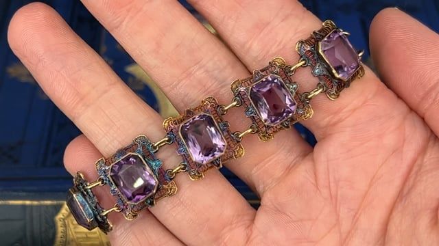 This fantastic vintage bracelet features nine (9) rectangular filigree links each accented with one (1) cut-cornered rectangular modified brilliant cut amethyst set into bezel settings. The links feature a pierced design with engraved details and bordered with milgrain edging. The bracelet measures 6-1/4 inches in length and 15.7mm in width. The bracelet is finished with a spring ring style clasp. The patina on this bracelet is spectacular. Antique Jewelry With Gemstone Accents For Formal Occasions, Antique Purple Bracelets For Formal Occasions, Luxury Purple Rectangular Jewelry, Art Deco Purple Jewelry For Formal Occasions, Purple Art Deco Jewelry For Formal Occasions, Purple Art Deco Jewelry For Formal Events, Ornate Formal Jewelry With Gemstone Accents, Ornate Gemstone Accents Jewelry For Formal Occasions, Ornate Rectangular Jewelry For Collectors