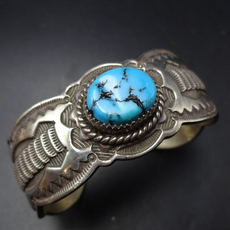 SIGNED VINTAGE NAVAJO BLUE KINGMAN TURQUOISE BRACELET DESCRIPTION:  With an abundance of hand-applied stamp work and a gorgeous specimen of natural blue Kingman turquoise, this bracelet will be a cherished addition to your collection of fine vintage Southwestern and Native American jewelry. MEASUREMENTS: Interior of the cuff measures 5 1/2" with an additional 1" slightly adjustable gap. Total circumference:  6 1/2" Measures 2 1/4" straight across the widest part  (from wrist bone to wrist bone) Classic Handmade Turquoise Bracelets, Vintage Blue Ceremonial Jewelry, Bohemian Stamped Blue Bracelets, Blue Stamped Bohemian Bracelets, Bohemian Blue Stamped Bracelets, Classic Handmade Cuff Bracelet Collectible, Southwestern Style Stamped Blue Bracelets, Vintage Stamped Blue Jewelry, Blue Vintage Stamped Jewelry