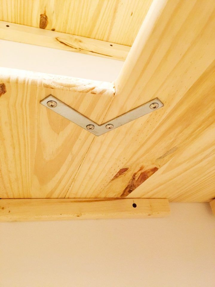 the corner of a wooden structure with metal brackets