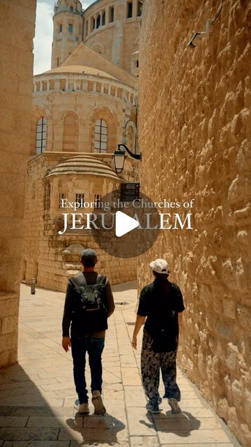 two men walking down an alley way in front of a building with a dome on top