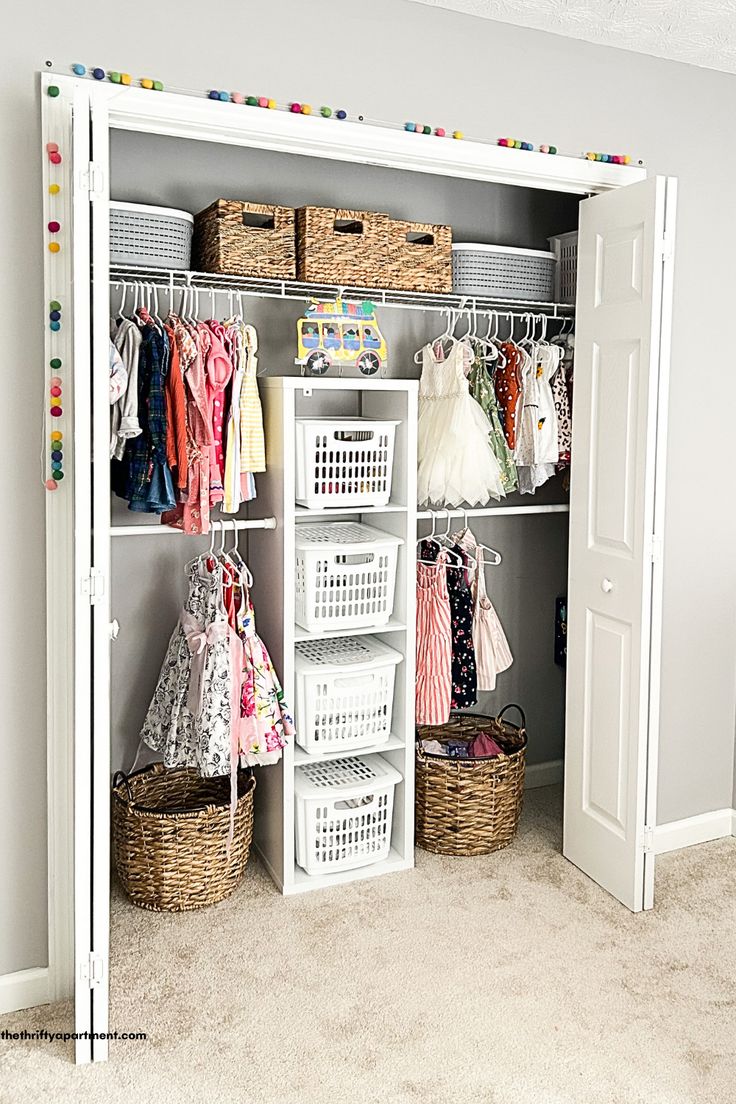 an organized closet with baskets, clothes and other items on it's shelves in a child's room