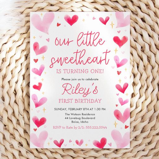 a pink and red heart birthday party card on a wicker basket with the words our little sweetheart is turning one