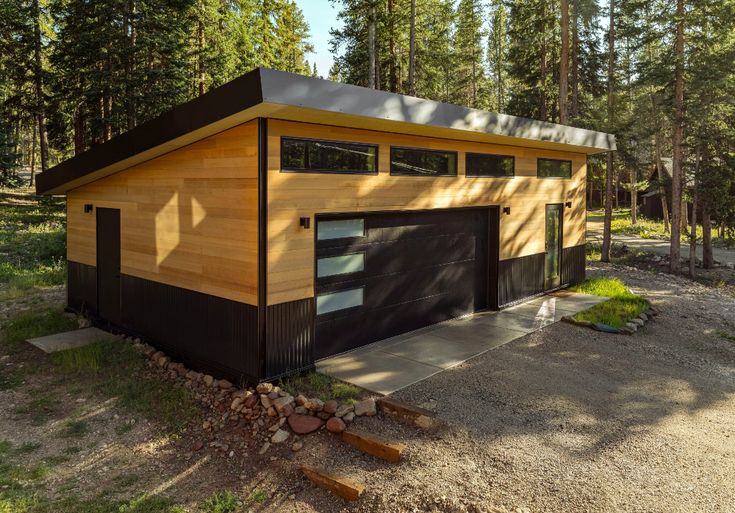 a two car garage in the middle of a forest