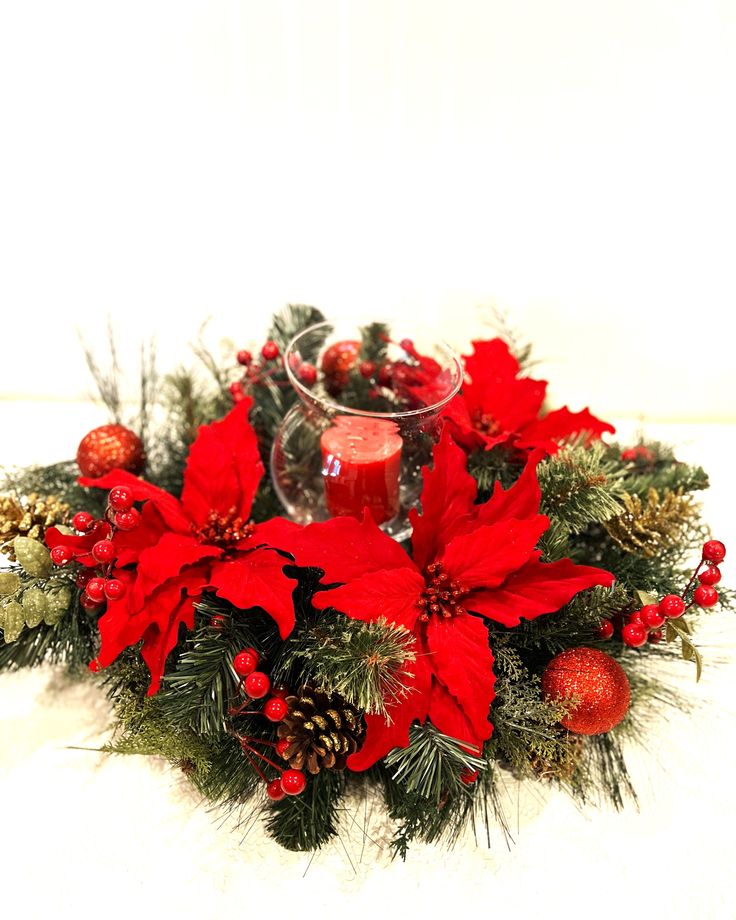 a christmas centerpiece with poinsettis and pine cones