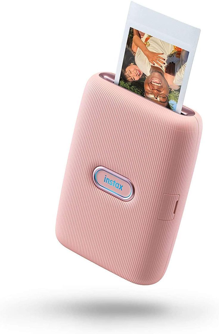 a pink cell phone with an instax photo in it's back pocket