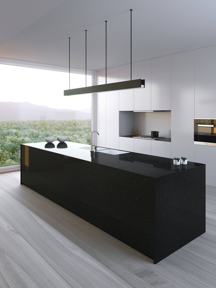 a modern kitchen with black counter tops and white cabinets, along with an island in the middle