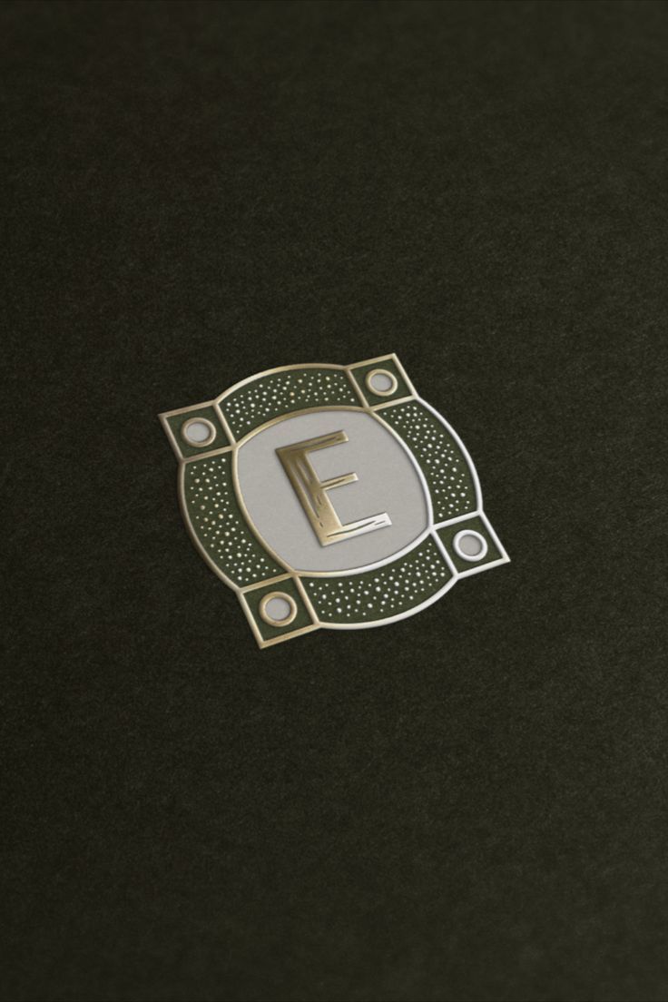 the letter e is placed on top of a black surface with gold trimmings