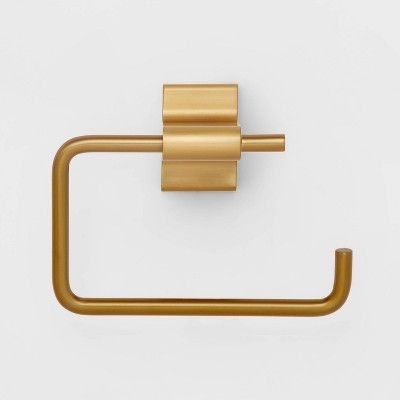 a gold toilet roll holder on a white wall