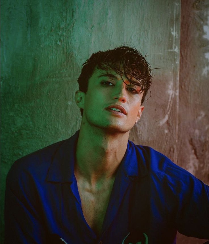 a young man in a blue shirt posing for a photo