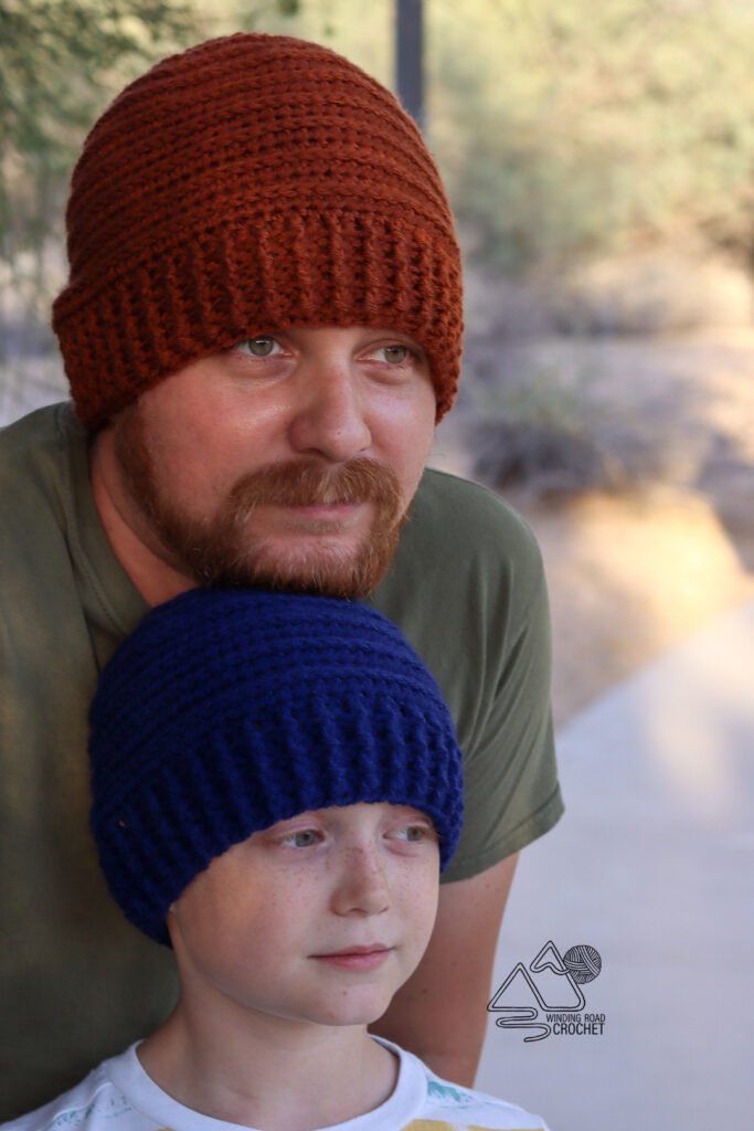 a man with a beard wearing a knitted hat next to a young boy