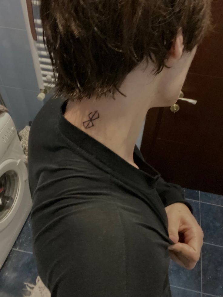 a woman with a cross tattoo on her neck standing in front of a washer