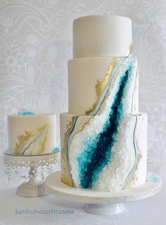 a three tiered cake with blue and white icing