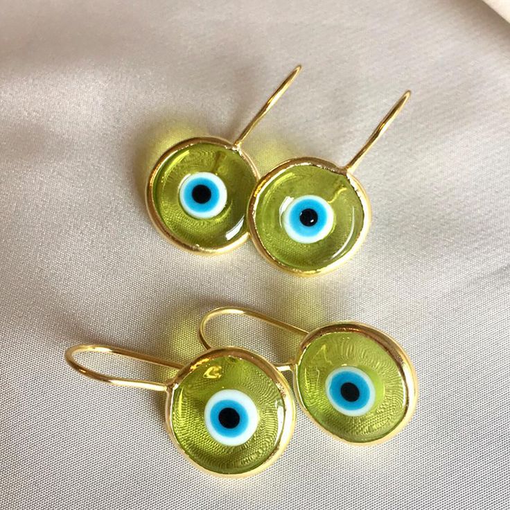 Inspired by our best-selling pendant, the breathtaking blend of colored glass and hand-painted designs in our Antique Evil Eye Earrings is bound to entice and astound. Unique in style and unmatchable in protective beauty, slip them on whenever you wish to make a strong impression, turn heads, and ignite the goddess within. 14k gold plated sterling Transparent eye .5" diameter disk Made by hand in Turkey, each piece is unique Study Core, Evil Eye Tattoo, Evil Eye Earrings, Painted Designs, Eye Tattoo, Eye Earrings, Gold Baby, The Goddess, Deep Red